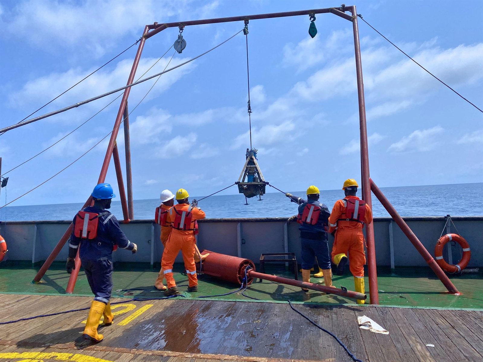 Quatenary field crew recovering a sediment grab sampler from the sea on an offshore survey